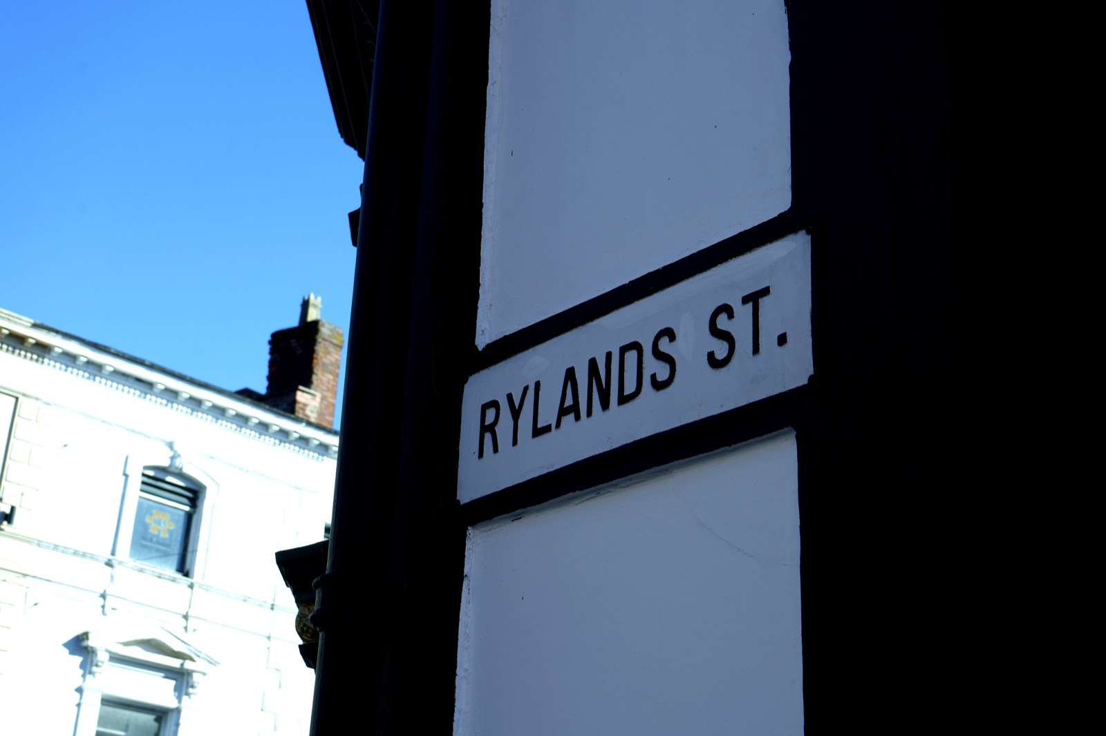 Rylands Street sign on the side of the college building